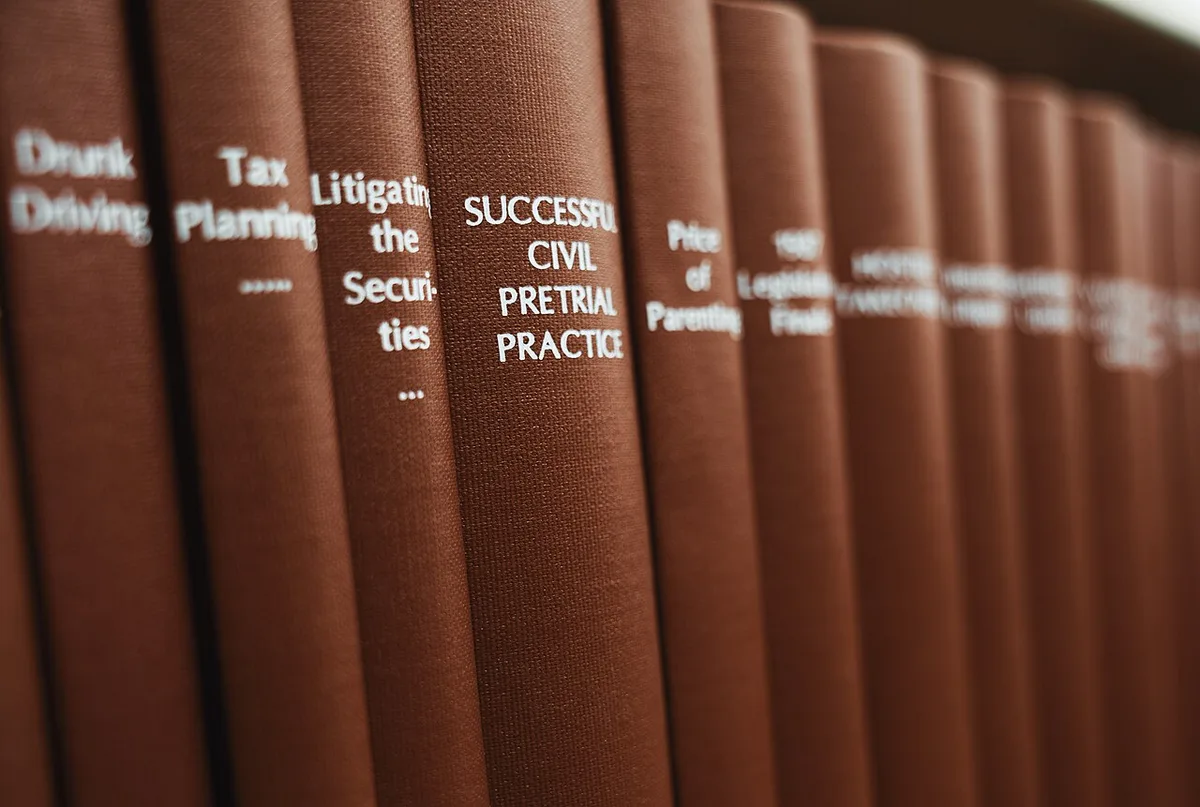 Stack of law books and a gavel on a wooden desk